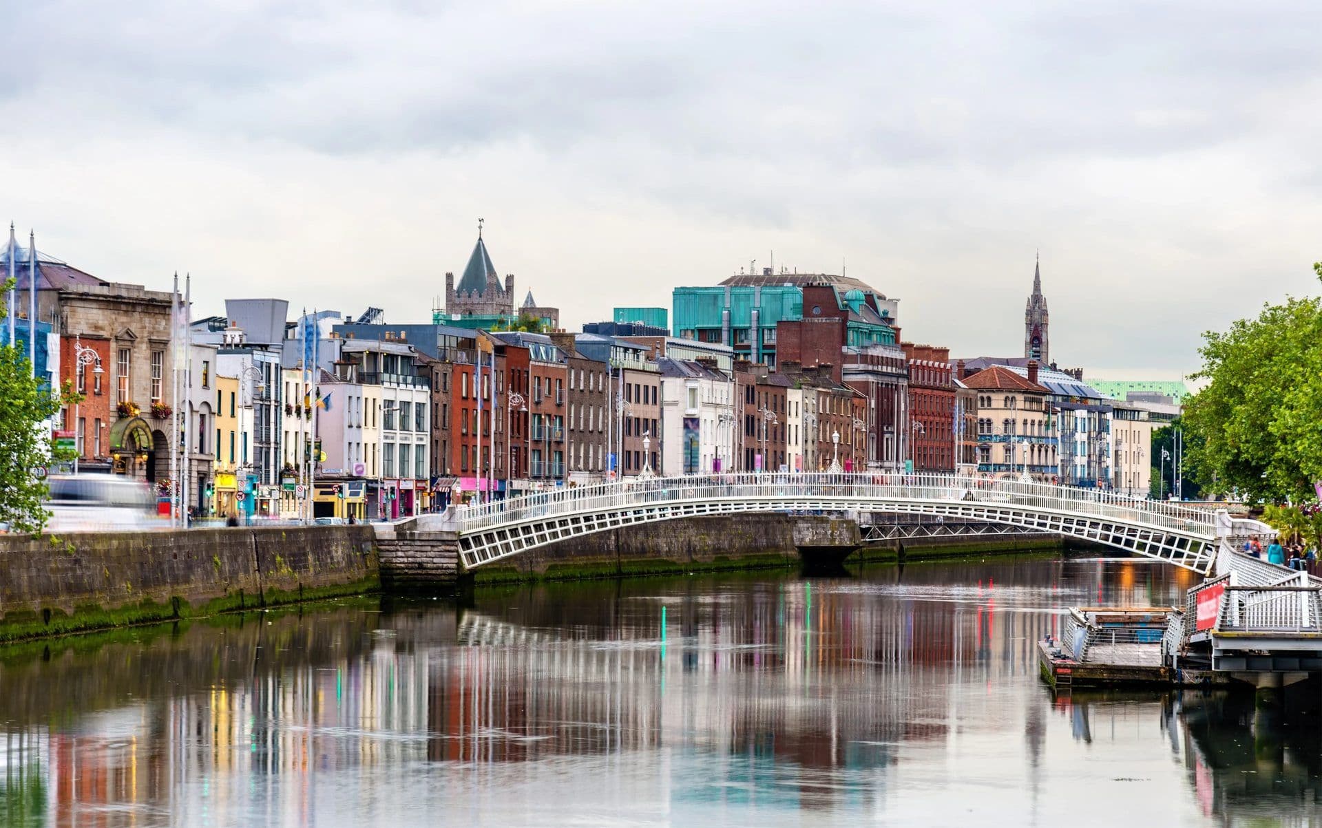 Dublin's Ha'penny Bridge over the River Liffey, flanked by historic buildings and potential waterfront venues.
