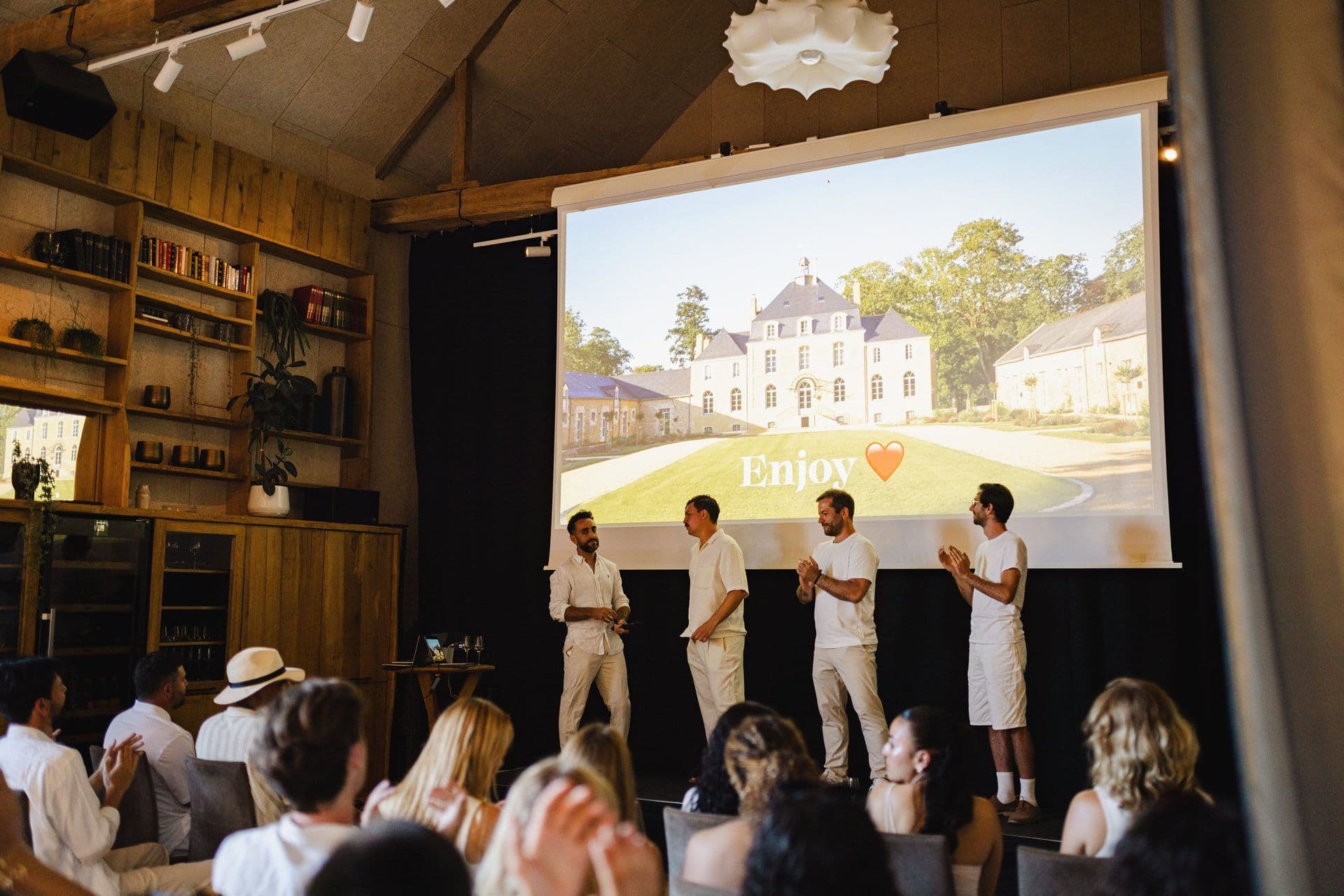 Presenters on stage at a corporate seminar in a unique event venue, displaying a French château.