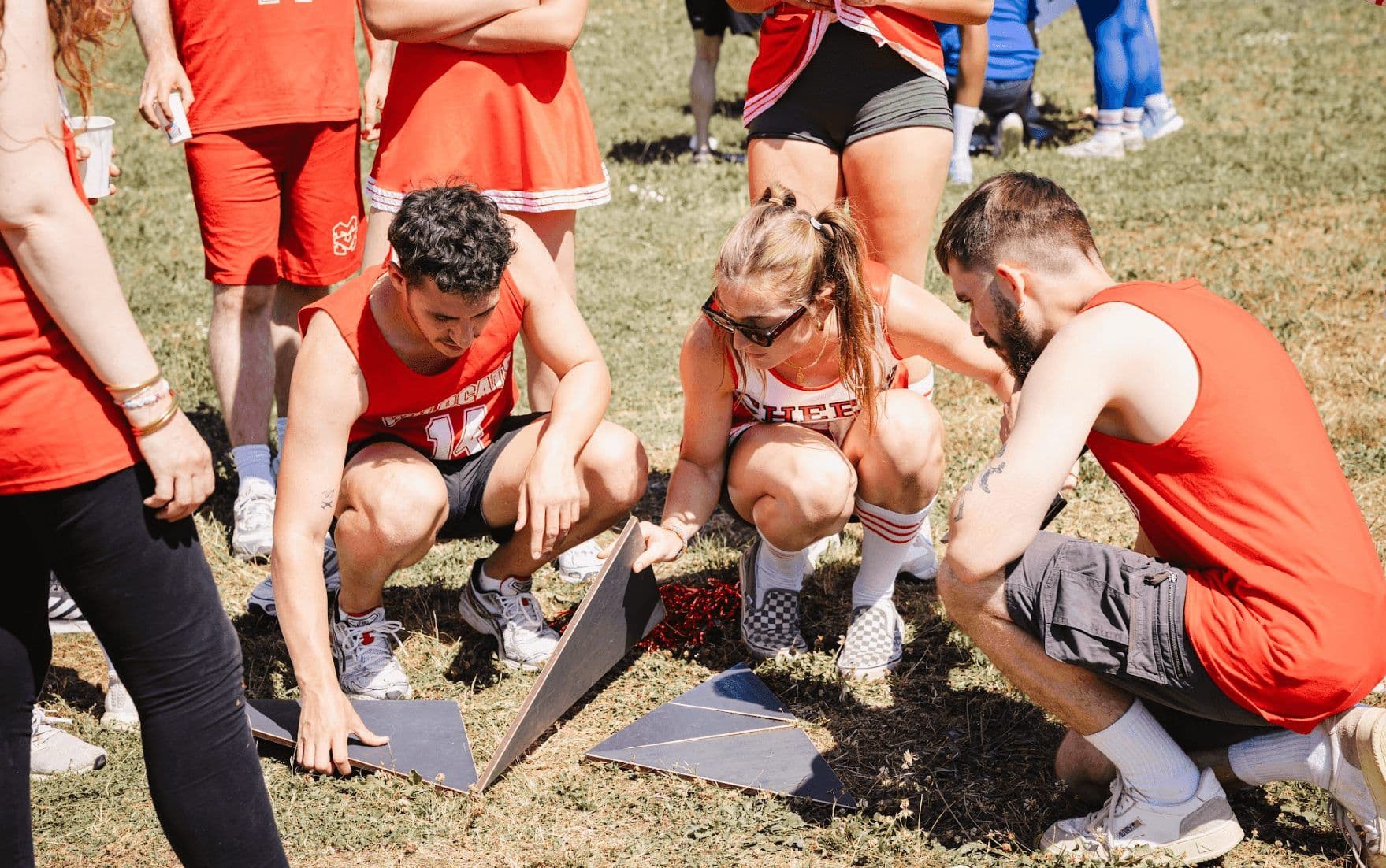 Group participating in an outdoor team-building activity, assembling geometric pieces on grass.