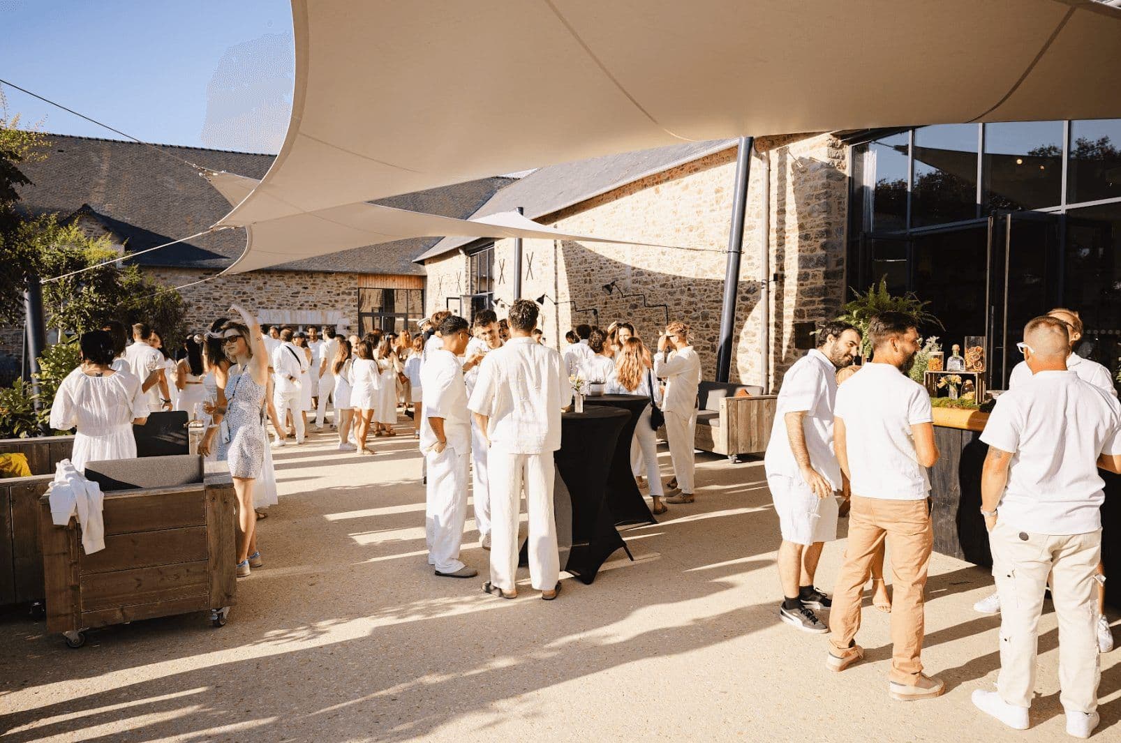 Attendees network at an outdoor enterprise event, enjoying a cocktail reception at a historic venue.