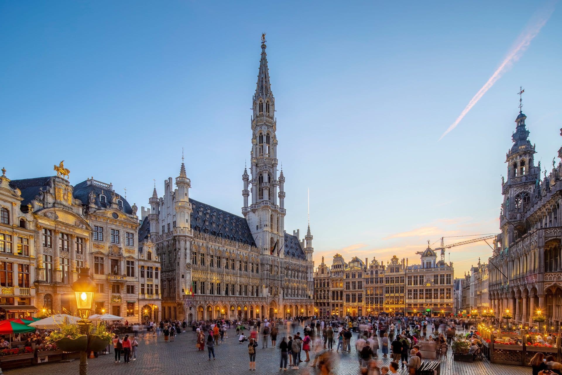 Brussels' historic Grand Place at dusk, with the illuminated Town Hall and ornate guildhalls