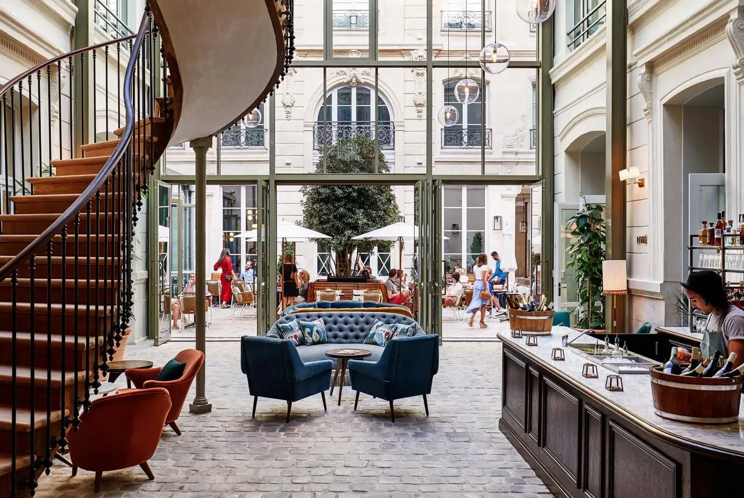 Elegant indoor-outdoor corporate event venue in Paris featuring a spiral staircase, lounge