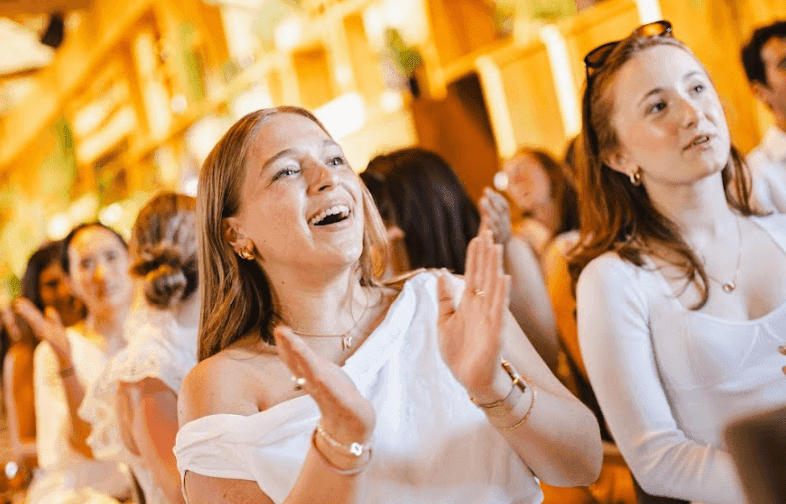 Engaged attendees clap and smile at a lively corporate event, perfect for a team offsite or seminar.