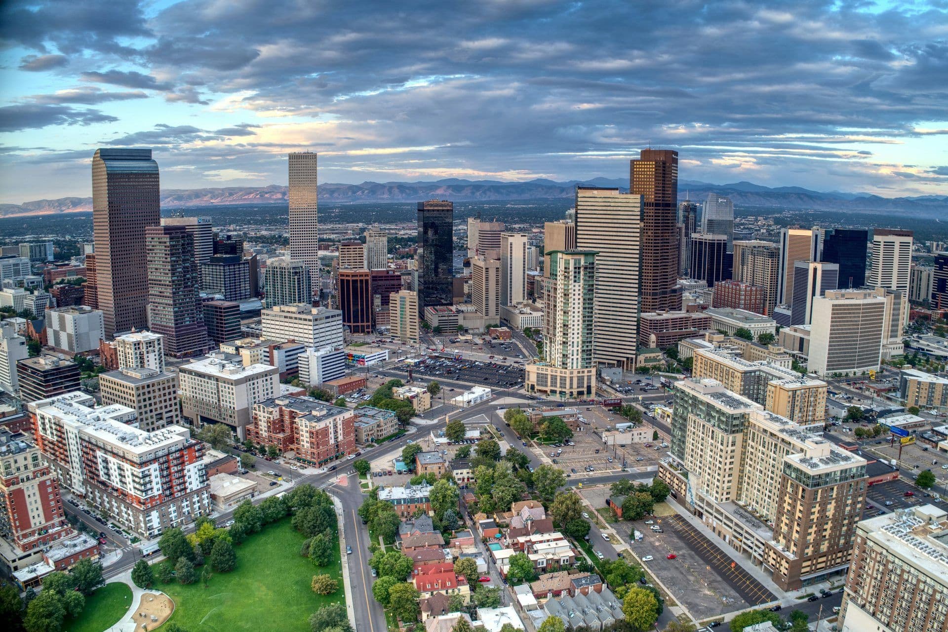 Downtown Denver, Colorado, skyline with modern corporate buildings and Rocky Mountains.