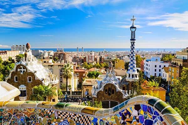 Vibrant mosaic wall and unique Gaudi architecture at Park Güell, Barcelona, overlooking the city.