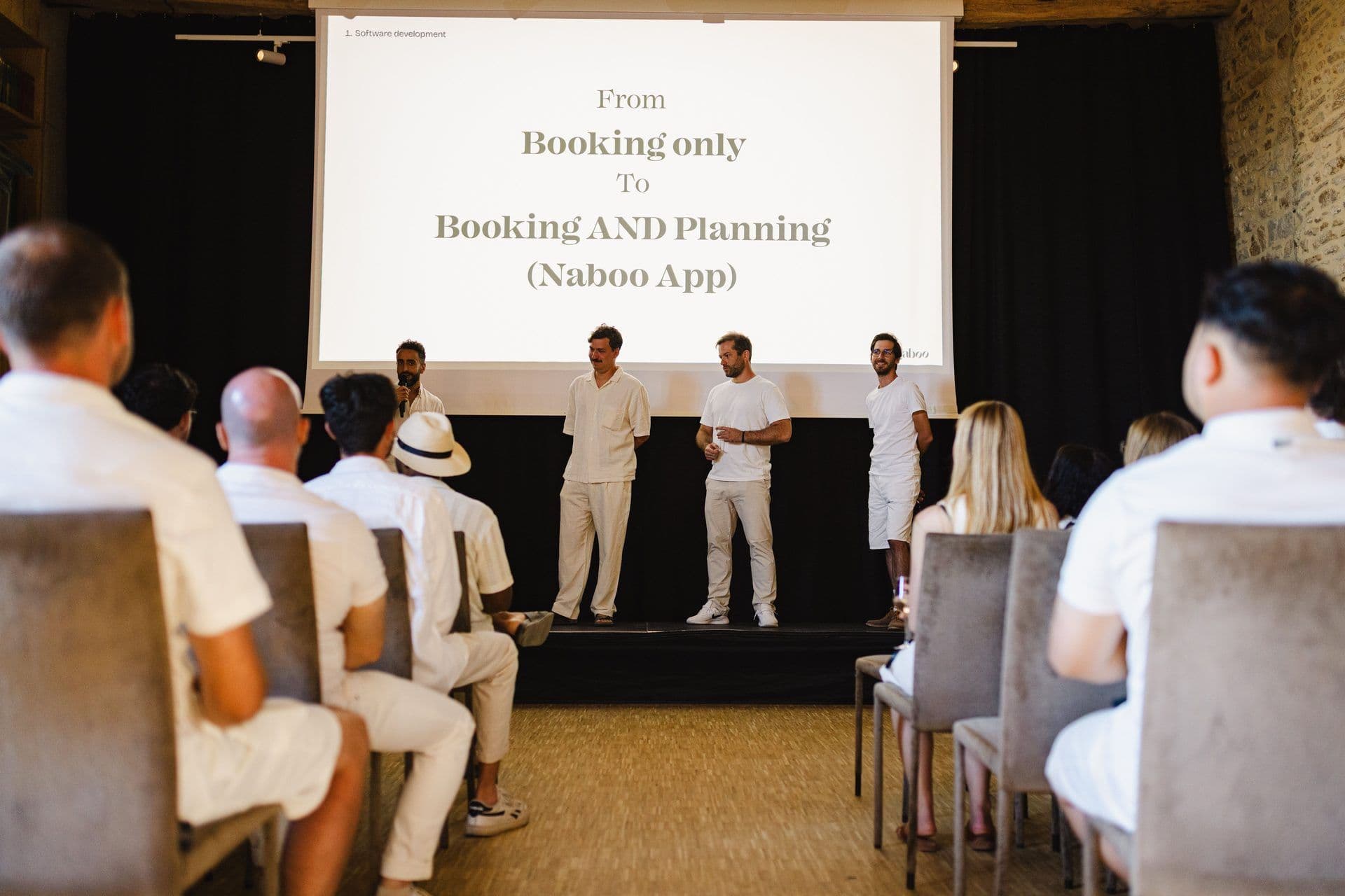 Attendees watch a presentation about the Naboo App at a corporate seminar in a unique event venue.