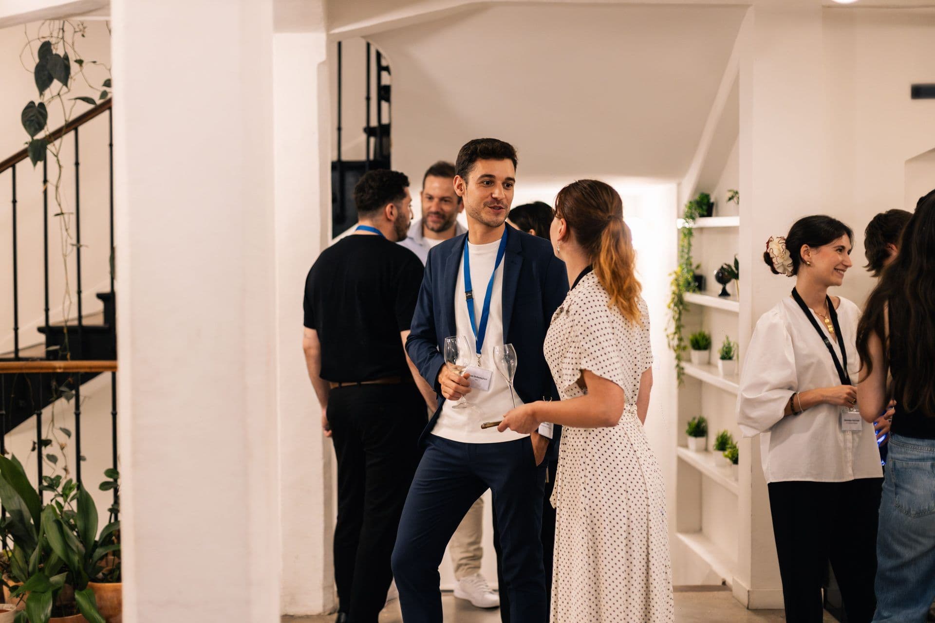 Attendees mingle and socialize at a corporate networking event in a bright, contemporary event space.
