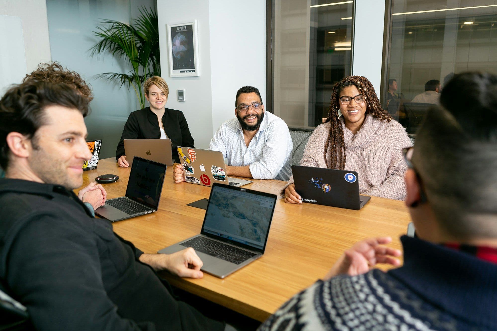 Colleagues gathered around laptops for a team meeting at the start of the season